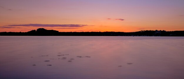 Scenic view of lake against orange sky during sunset