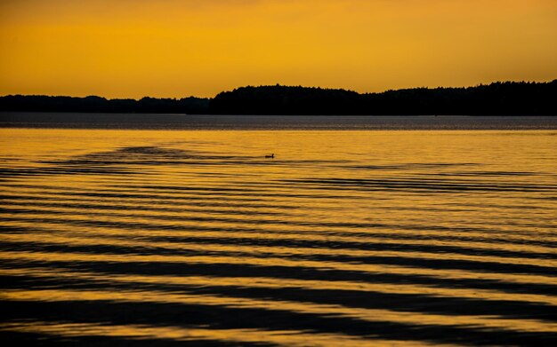 Scenic view of lake against orange sky