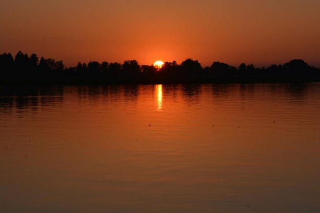 Scenic view of lake against orange sky