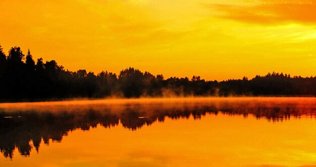 Scenic view of lake against orange sky