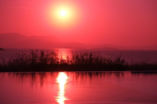 Scenic view of lake against romantic sky at sunset