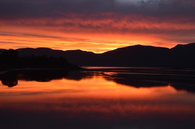 Scenic view of lake against romantic sky at sunset