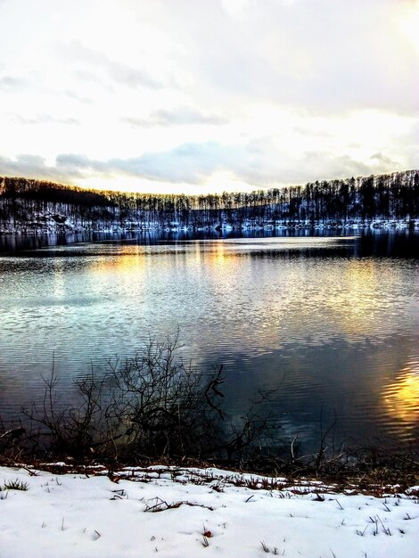 Scenic view of lake against sky during winter