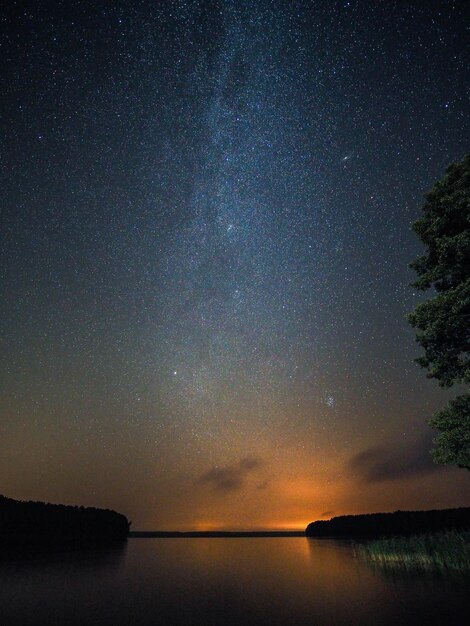 Scenic view of lake against sky at night