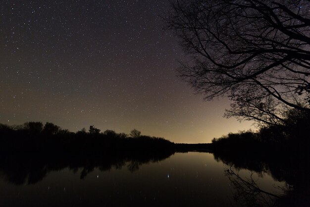 Scenic view of lake against sky at night