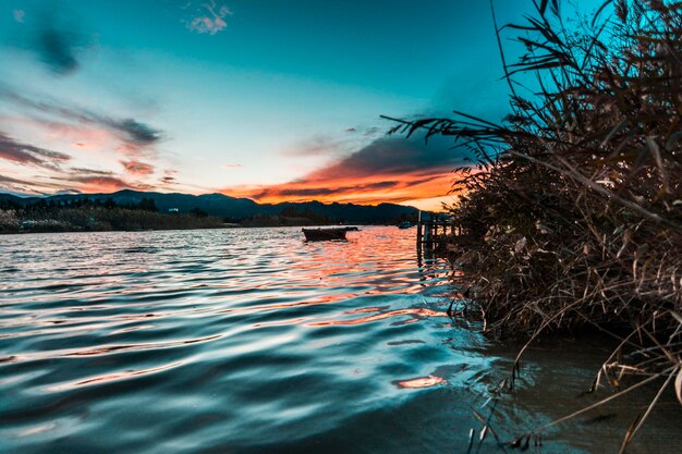 Scenic view of lake against sky at sunset