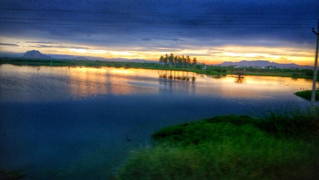 Scenic view of lake against sky at sunset