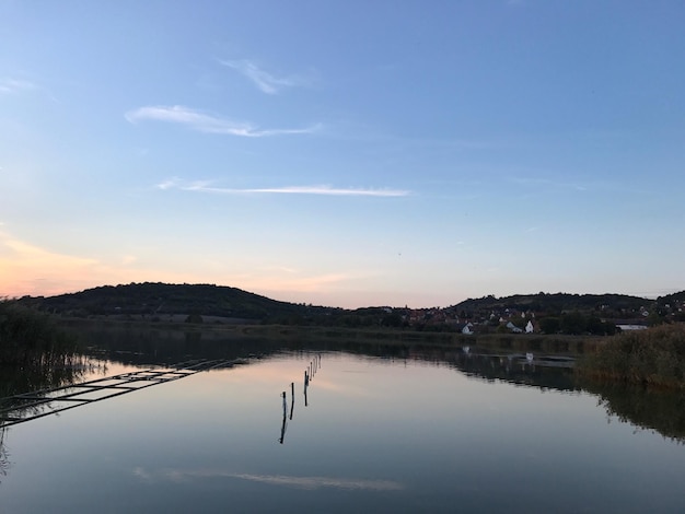 Scenic view of lake against sky at sunset