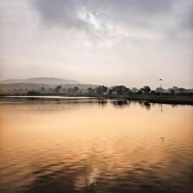 Scenic view of lake against sky at sunset