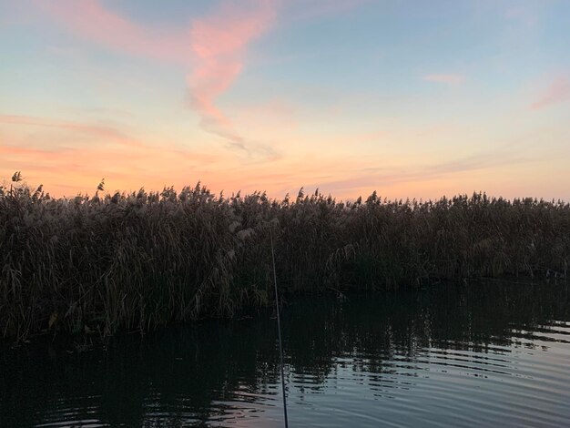 Scenic view of lake against sky at sunset