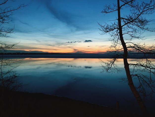 Scenic view of lake against sky at sunset