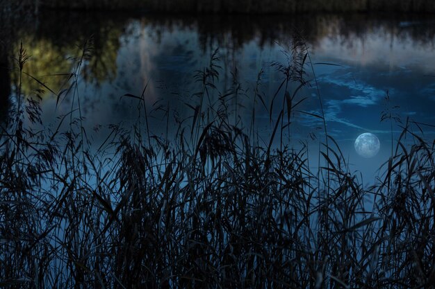 Photo scenic view of lake against sky with reflected full moon  during sunset