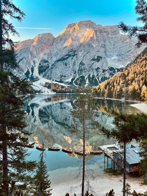 Scenic view of lake of braies by snowcapped mountains against sky