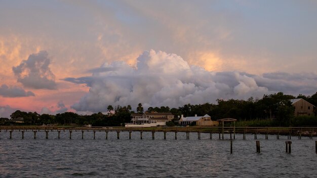 Scenic view of lake by building against sky during sunset