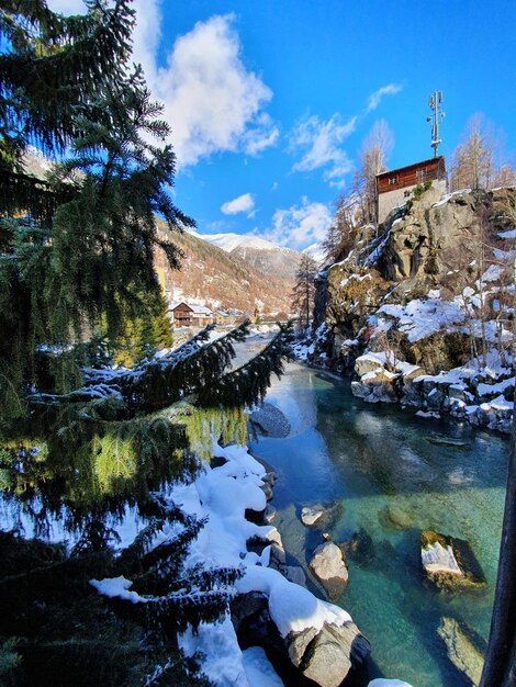 Scenic view of lake by building against sky during winter