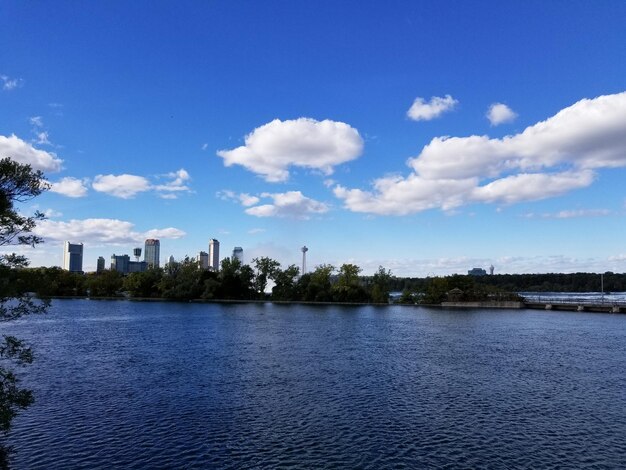 Scenic view of lake by buildings against blue sky