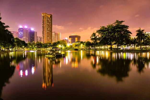 Photo scenic view of lake by buildings against sky at night