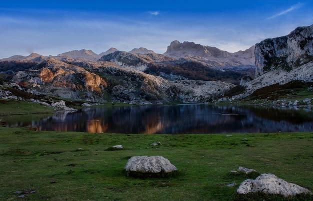 Scenic view of lake by mountain range against blue sky