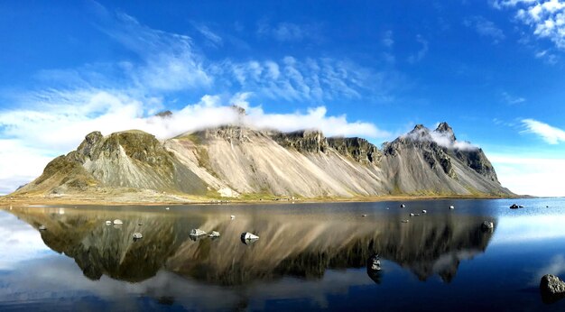 Scenic view of lake by mountains against blue sky