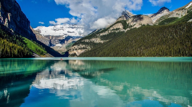 Scenic view of lake by mountains against sky