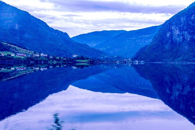 Scenic view of lake by mountains against sky