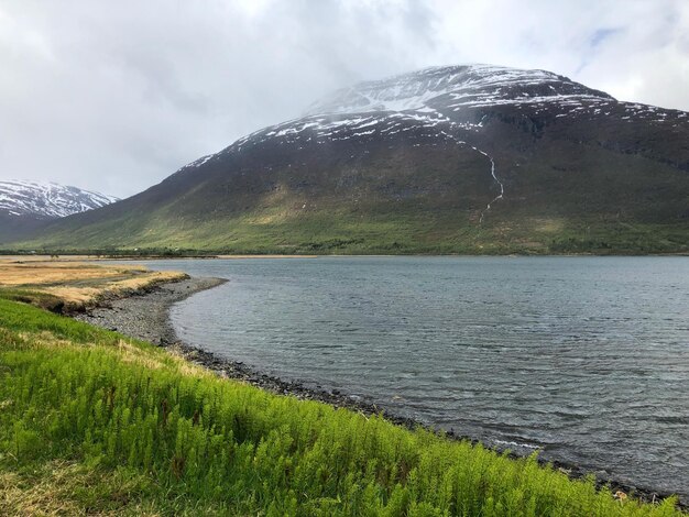 Scenic view of lake by mountains against sky