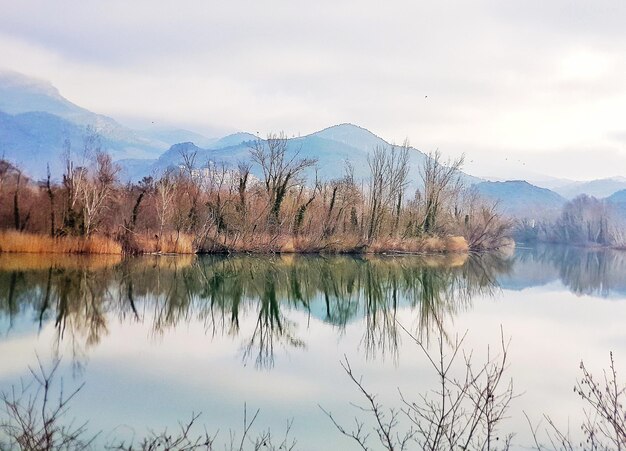 Scenic view of lake by mountains against sky