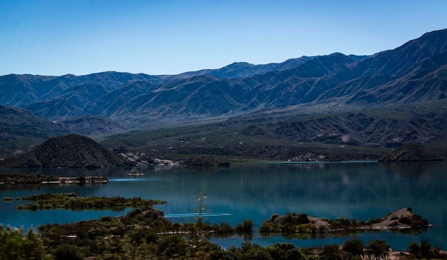 scenic view of lake by mountains against sky