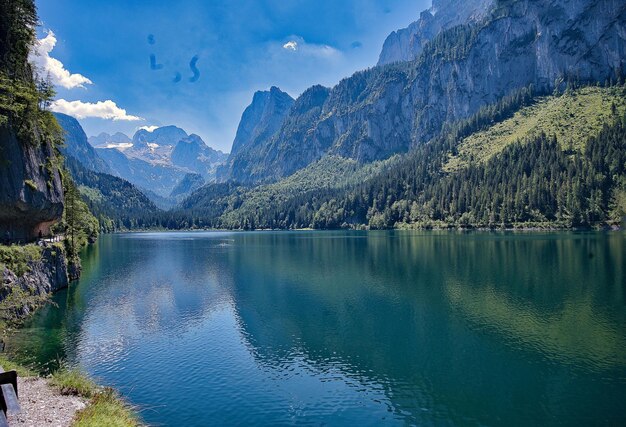 Scenic view of lake by mountains against sky