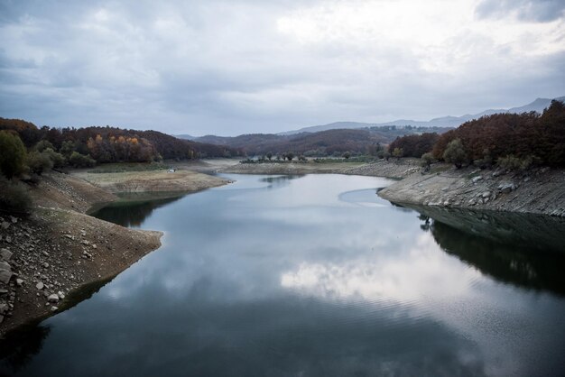 Photo scenic view of lake by mountains against sky