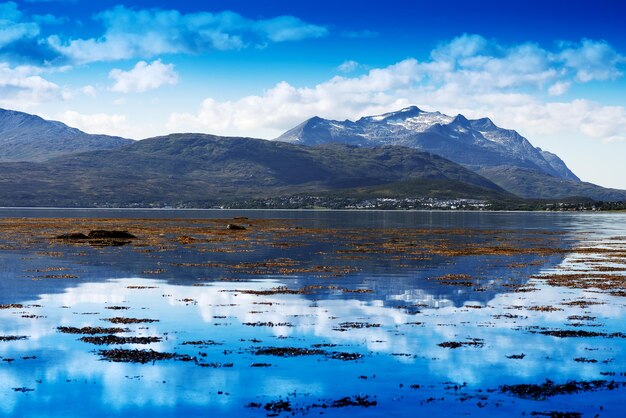 Scenic view of lake by mountains against sky