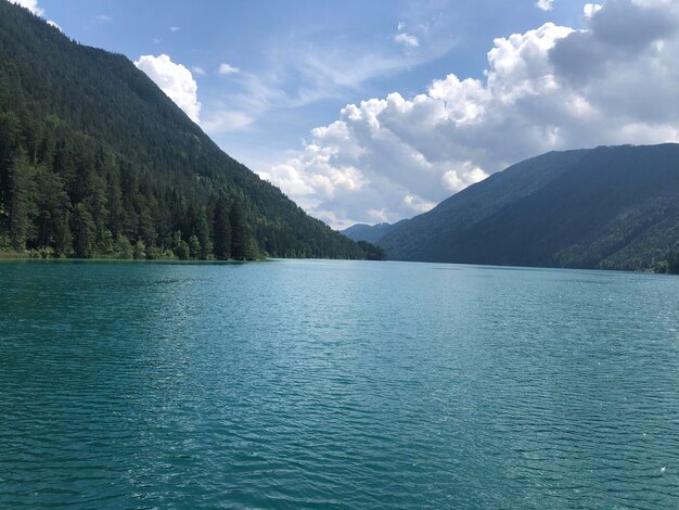 Photo scenic view of lake by mountains against sky