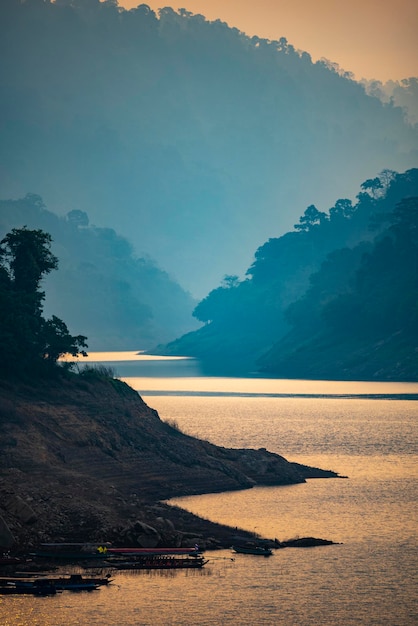 scenic view of lake by mountains during sunset