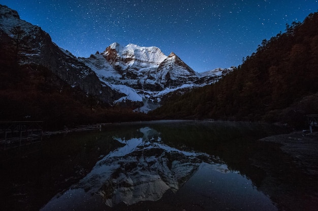 Photo scenic view of lake by snowcapped mountains against sky at night