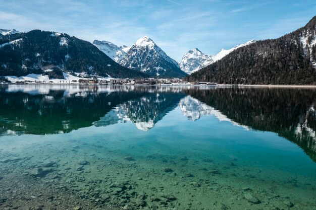 Foto vista panoramica del lago da montagne innevate contro il cielo