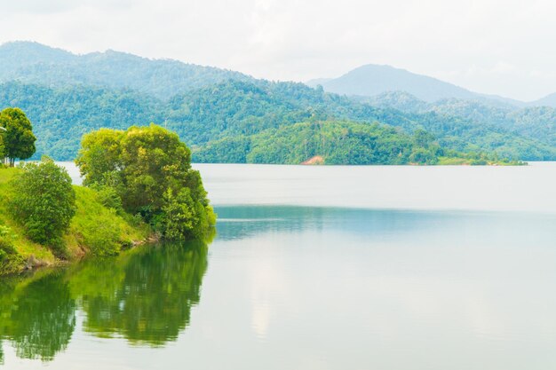 Scenic view of lake by trees against sky