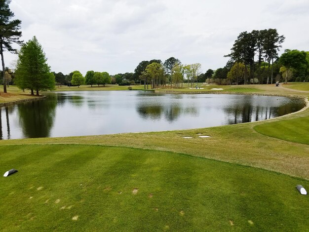 Photo scenic view of lake in golf course against cloudy sky