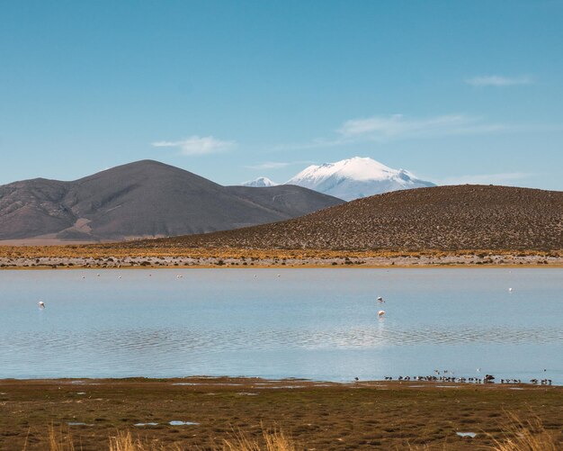 Scenic view of lake and mountains against blue sky