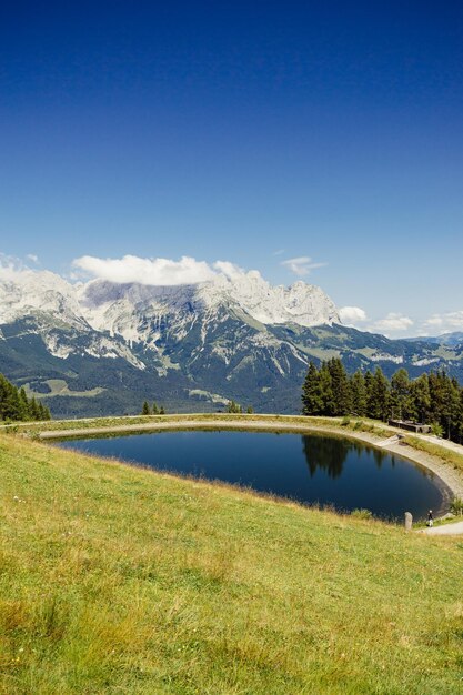 Scenic view of lake and mountains against blue sky