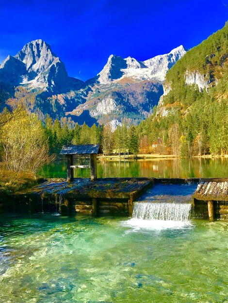 Scenic view of lake and mountains against blue sky