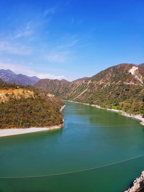 Scenic view of lake and mountains against blue sky