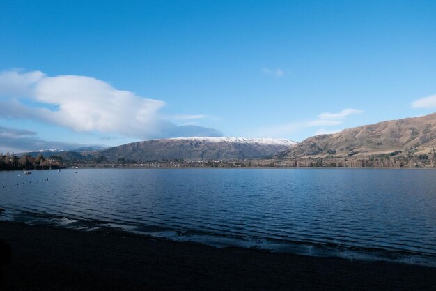 Scenic view of lake and mountains against blue sky