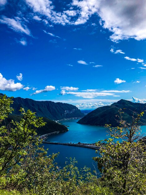 Scenic view of lake and mountains against blue sky