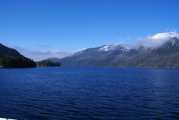 Scenic view of lake and mountains against blue sky