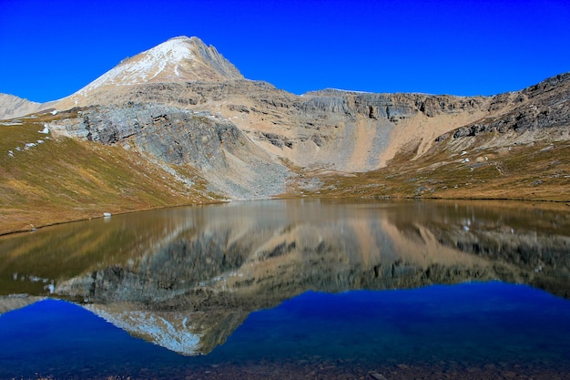 Scenic view of lake and mountains against blue sky