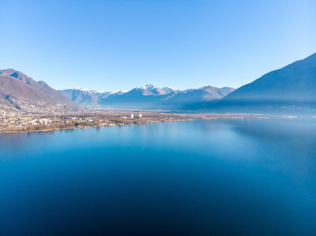 Scenic view of lake and mountains against clear blue sky