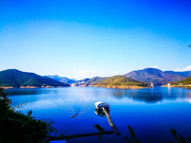 Photo scenic view of lake and mountains against clear blue sky