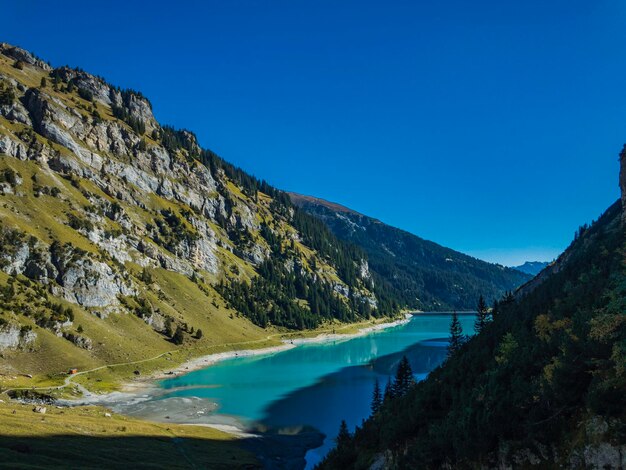 Photo scenic view of lake and mountains against clear blue sky