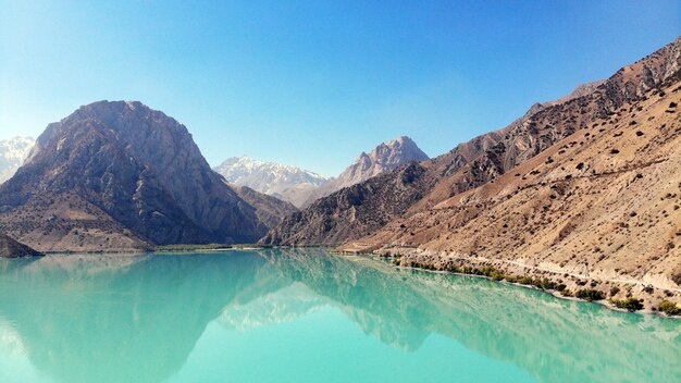 Photo scenic view of lake and mountains against clear blue sky