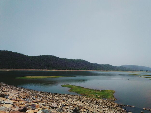 Scenic view of lake and mountains against clear sky